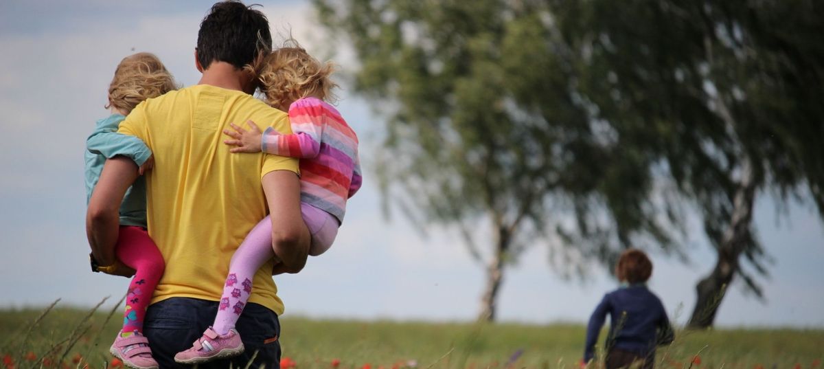 Papa mit seinen Kindern auf einer Wiese Papa mit seinen Kindern auf einer Wiese