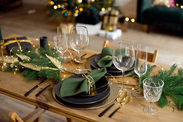 Weihnachtstafel mit Platzsets aus Metall und Stoffservietten