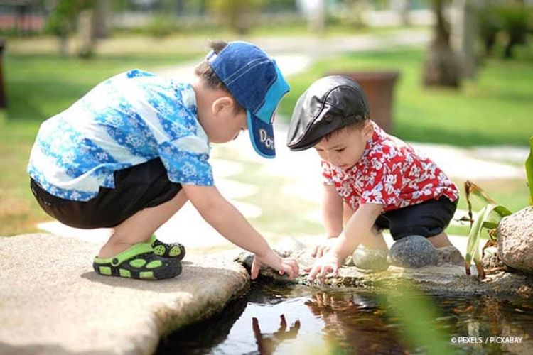 Kinder spielen am Teich