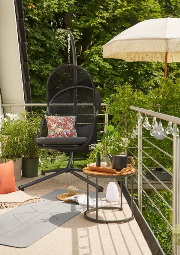 Boho Balkon mit Hängesessel, Lichterkette und Sonnenschirm